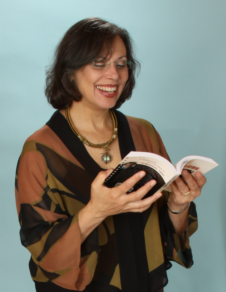 Judy Baker laughs while holding a book